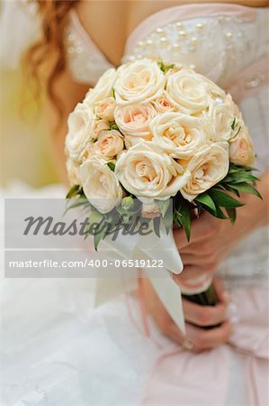 bride holds a wedding bouquet of roses