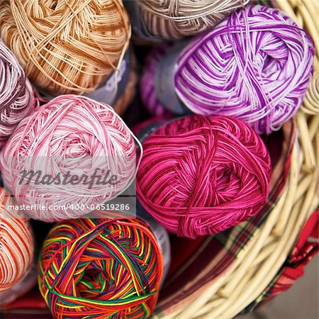 balls of knitted wool in basket, closeup