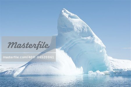 Icebergs in the sunny bright light on the background of the island.