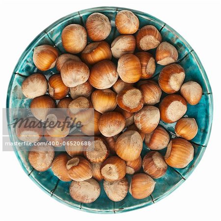 Plate of hazelnuts isolated on white background