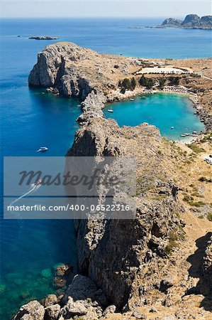 A blue lagoon near the town of Lindos on the Greek island of Rhodos highlights the deep blue waters.