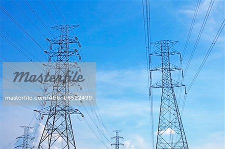 high voltage power pylons on sky blue