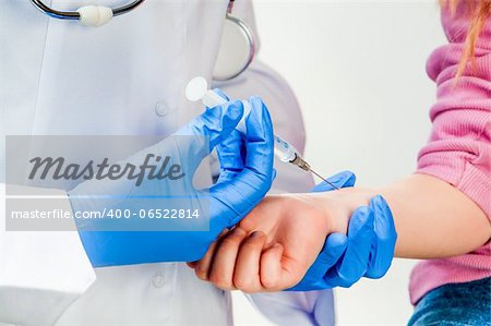 Child receiving a vaccination immunisation by a doctor close up