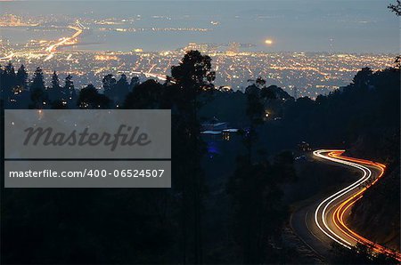 Cars leave light trails as they ascend and descend Skyline Blvd. high above the San Francisco bay.