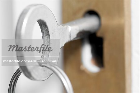 Macro photo of old style house key in door lock.