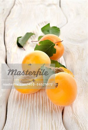 Ripe apricots on a white wooden background