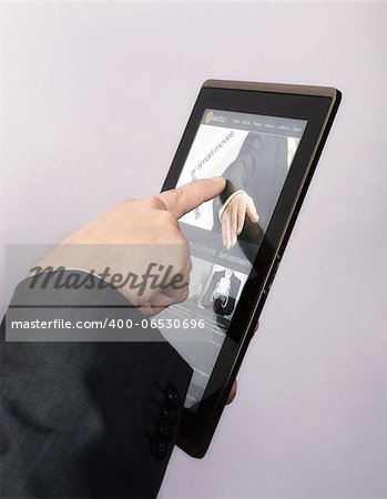Finger touching screen on tablet-pc and browsing a website.