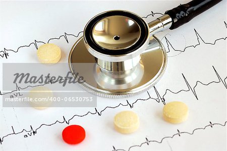 A stethoscope on the top of the EKG chart with pills concept of modern medicine