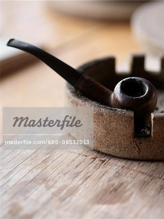 wooden pipe sitting in an ashtray on a wooden tabletop, Canada wooden pipe sitting in an ashtray on a wooden tabletop, Canada