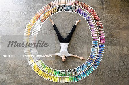 Businessman laying in paint swatches