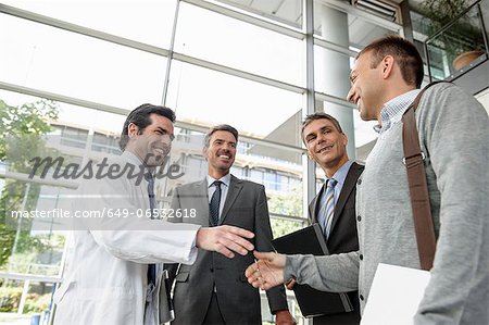 Doctor and businessman shaking hands