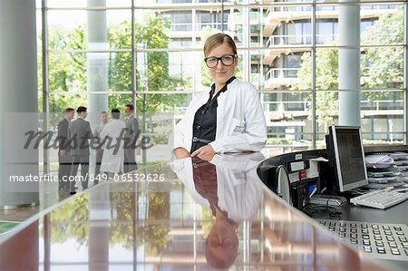 Doctor leaning on secretarys desk