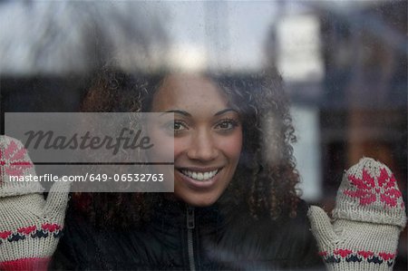 Woman wearing mittens at window