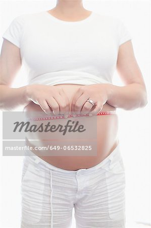 Pregnant woman measuring belly