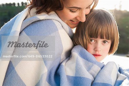 Mother and daughter wrapped in blanket