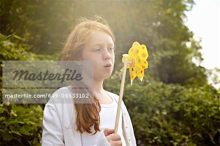 Girl playing with pinwheel outdoors