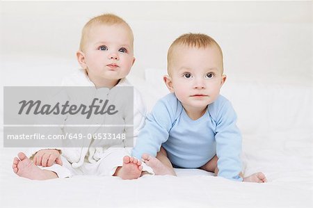 Babies sitting together on sofa