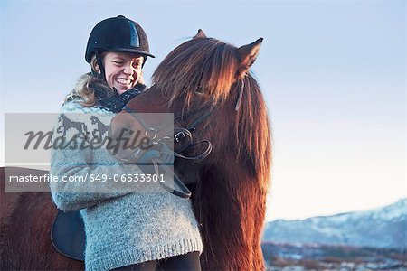 Woman smiling with horse outdoors