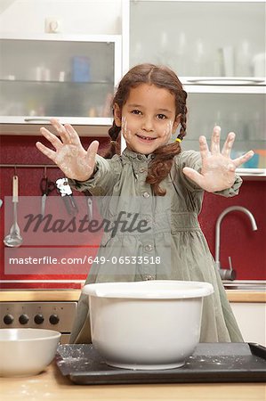 Girl with sticky hands in kitchen