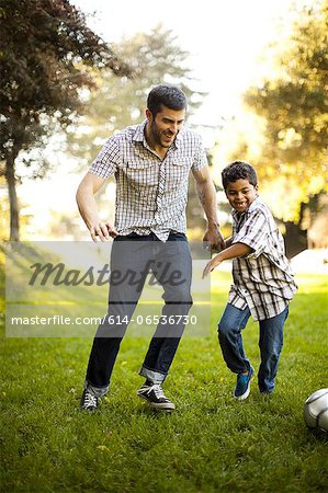 Father and son playing soccer together