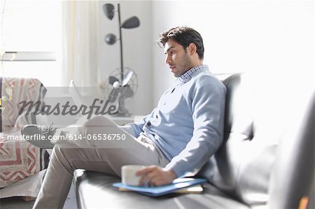 Man using laptop on sofa Man using laptop on sofa