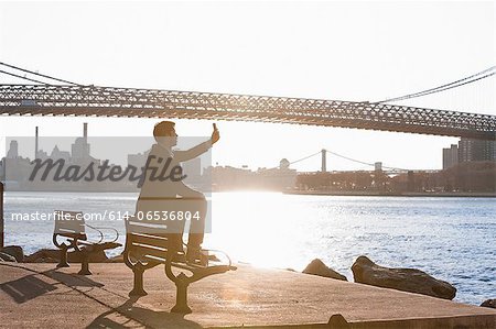 Man taking pictures of urban bridge