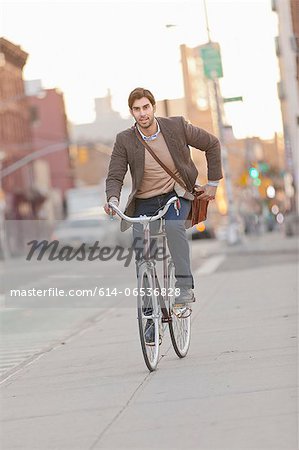 Man riding bicycle on city street Man riding bicycle on city street