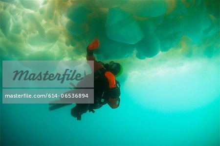 Man scuba diving under glacier