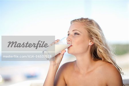 Woman drinking glass of milk outdoors