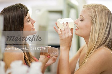 Women smelling candles in store