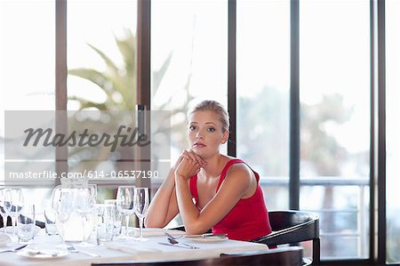 Woman sitting at restaurant table Woman sitting at restaurant table