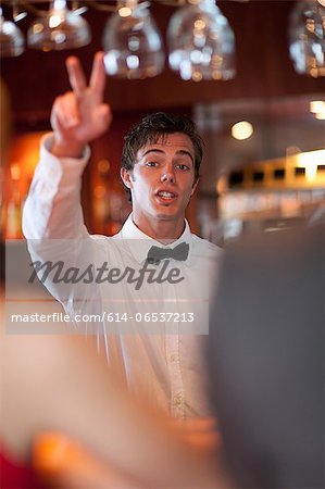 Waiter offering more drinks at bar