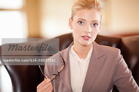 Businesswoman holding glasses at desk
