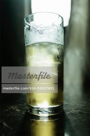 Glass of beer illuminated on bar