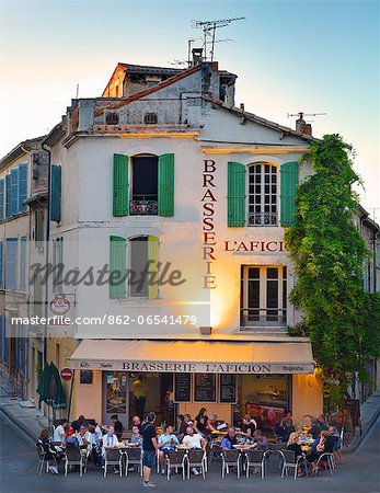 France, Provence, Arles, People at brasserie infront of Amphitheatre at dusk