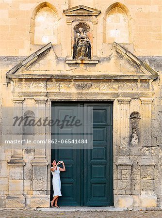 France, Provence, Arles, Notra Dame de la Major, Woman taking photograph in church doorway. MR France, Provence, Arles, Notra Dame de la Major, Woman taking photograph in church doorway. MR