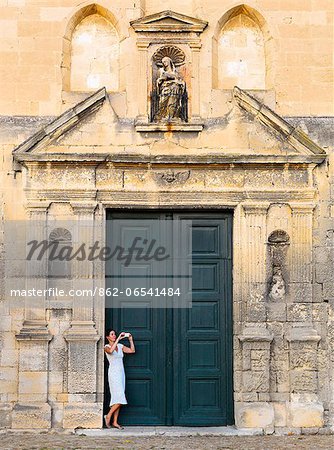 France, Provence, Arles, Notra Dame de la Major, Woman taking photograph in church doorway. MR