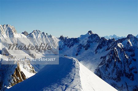 Europe, France, French Alps, Haute Savoie, Chamonix, Aiguille du Midi, skiers walking down the ridge at the start of Vallee Blanche off piste