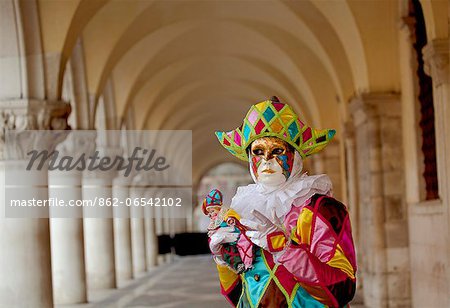 Venice, Veneto, Italy, Mask under the arches of the Palazzo dei Dogi on Piazza San Marco during carnival.