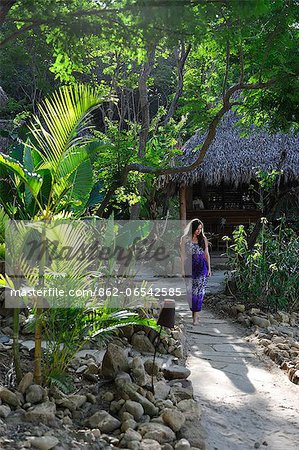 Woman walking through tropical gardens at the Aqua Wellness Resort, Nicaragua, Central America