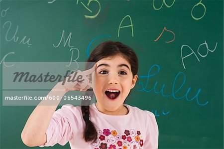 Portrait of Girl in Front of Chalkboard in Classroom