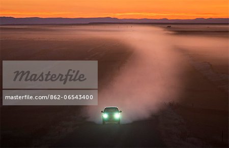 Car on gravel road in Badlands, South Dakota, USA