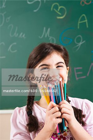 Girl Holding Coloured Pencils in Classroom, Baden-Wurttemberg, Germany