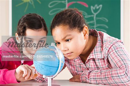 Portrait of Girls Looking at Globe in Classroom, Baden-Wurttemberg, Germany