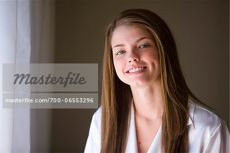 Portrait of Smiling Woman with Brown Hair by Window