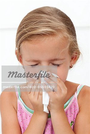 Little girl with the flu blowing nose - closeup