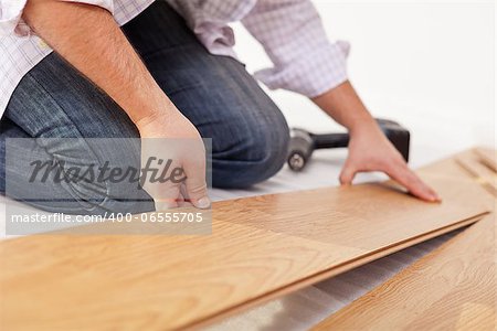 Man laying laminate flooring - closeup on hands