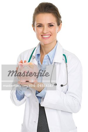 Smiling medical doctor woman holding piggy bank