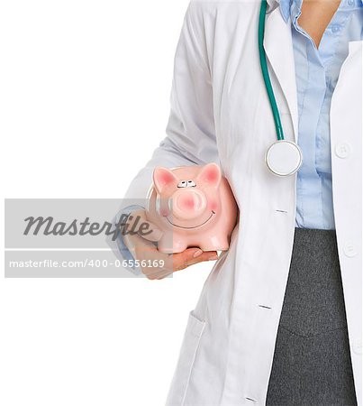 Closeup on medical doctor holding piggy bank