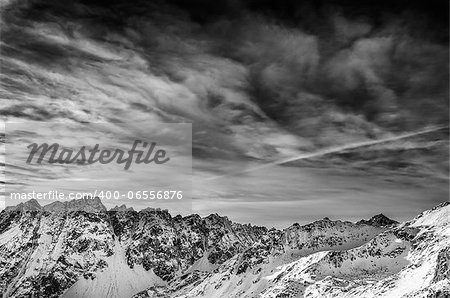 Winter mountains landscape with dark blue cloudy sky